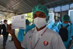 Seorang nakes Myanmar memperlihatkan tanda terima vaksin di Pusat Perawatan Covid Ayeyarwaddy di Yangon, Myanmar, 27 Januari 2021.