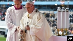 Pope Francis is flanked by Vatican Master of Ceremonies, Mons. Guido Marini as he celebrates a Mass at the Malmo stadium, Sweden, Nov. 1, 2016.