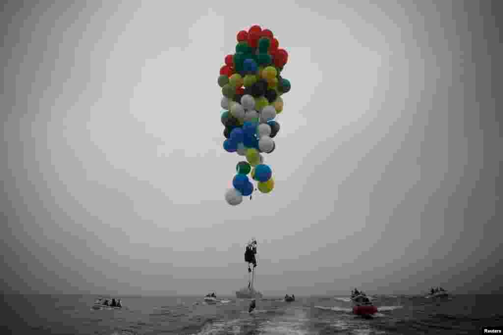 South Africa&#39;s Matt Silver-Vallance floats above the sea using helium-filled balloons from the airfield of Robben Island across the Atlantic Ocean in Cape Town. Vallance made the 7-km flight to raise funds and awareness for the Mandela Children&#39;s Hospital.