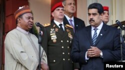 OPEC Secretary-General Mohammed Barkindo talks to reporters while standing with Venezuela's President Nicolas Maduro after their meeting at Miraflores Palace in Caracas, Venezuela, Nov. 16, 2016.