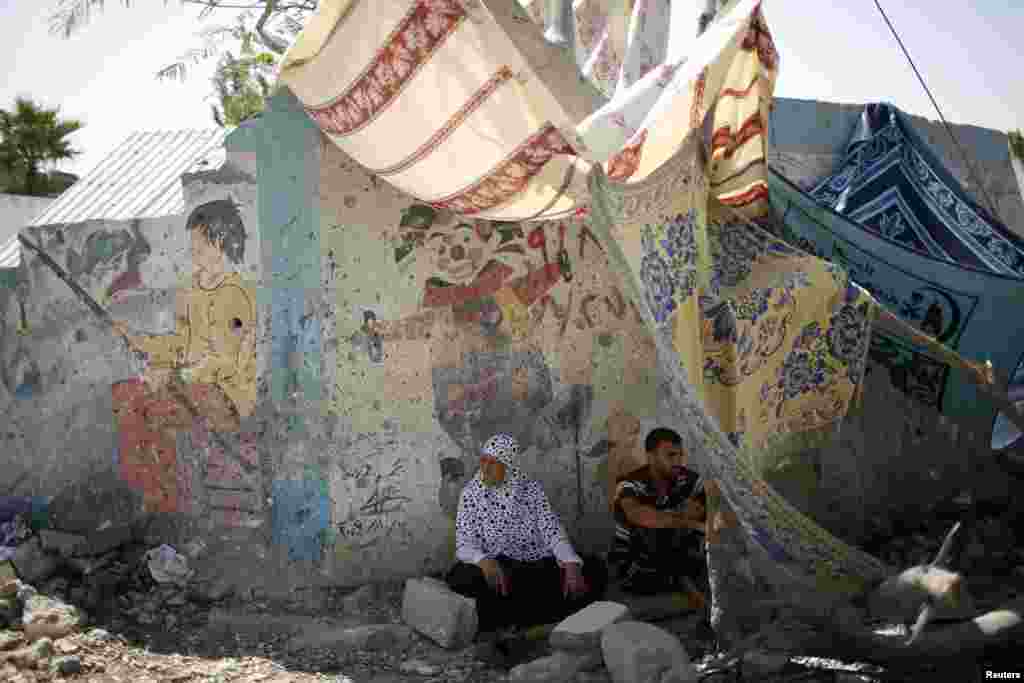 A man and a woman share a makeshift shelter in Beit Hanoun town, Aug. 11, 2014.