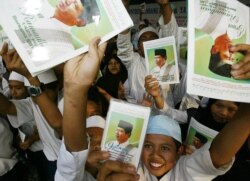 Ilustrasi. Sekelompok siswa Indonesia memegang foto kandidat presiden Susilo Bambang Yudhoyono di sebuah sekolah Islam di Bandung, 27 Agustus 2004. (Foto: Reuters/Beawiharta)