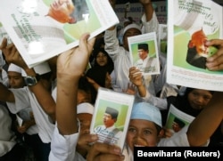 Ilustrasi. Sekelompok siswa Indonesia memegang foto kandidat presiden Susilo Bambang Yudhoyono di sebuah sekolah Islam di Bandung, 27 Agustus 2004. (Foto: Reuters/Beawiharta)