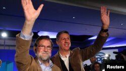 Spanish Prime Minister Mariano Rajoy and Catalan People's Party (PP) president Xavier Garcia Albiol wave as they arrive at a Catalan regional People's Party meeting in Barcelona, Nov. 12, 2017. 
