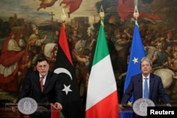 Italian Prime Minister Paolo Gentiloni (R) listens to his Libyan counterpart Fayez al-Sarraj during a news conference at Chigi Palace in Rome, Italy, July 26, 2017.