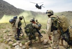 Tentara Amerika bersiap untuk menaiki helikopter sekitar 60 kilometer sebelah utara Kandahar, Afghanistan, 20 Mei 2003. (Kamal Kishore/AFP)