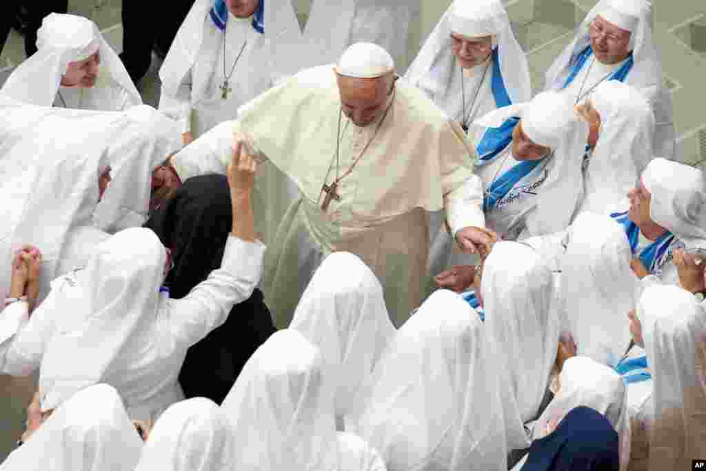 Vatikan&rsquo;da haftalık konuşmasından önce rahibelerle selamlaşan Papa Francis. 