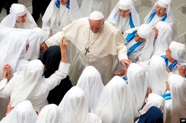 Pope Francis is greeted by a group of nuns during his weekly general audience in the Pope Paul VI hall at the Vatican, Wednesday, Aug. 22, 2018.