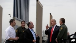 President Donald Trump reviews border wall models, March 13, 2018, in San Diego. (AP Photo/Evan Vucci)