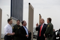 FILE - President Donald Trump reviews border wall prototypes in San Diego, March 13, 2018.
