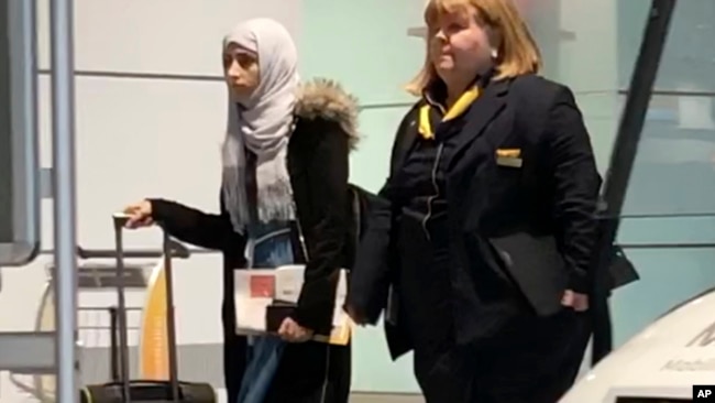 Yemeni national Shaima Swileh, left, walks through the airport in Munich, Germany, Dec. 19, 2018, before boarding a plane to the U.S., where she wants to give her son one more kiss before he dies.