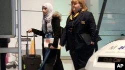 Yemeni national Shaima Swileh, left, walks through the airport in Munich, Germany, Dec. 19, 2018, before boarding a plane to the U.S., where she wants to give her son one more kiss before he dies.