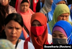 Pekerja pabrik sepatu berjalan pulang setelah pulang kerja, di kawasan industri Pasar Kemis di Tangerang 14 Agustus 2014. (Foto: Reuters/Beawiharta)