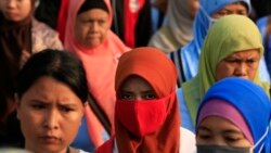 Pekerja pabrik sepatu berjalan pulang setelah pulang kerja, di kawasan industri Pasar Kemis di Tangerang 14 Agustus 2014. (Foto: Reuters/Beawiharta)