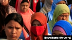 Pekerja pabrik sepatu berjalan pulang setelah pulang kerja, di kawasan industri Pasar Kemis di Tangerang 14 Agustus 2014. (Foto: Reuters/Beawiharta)