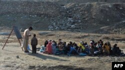 Anak-anak bersekolah di luar ruangan, di distrik Qarghayi, Provinsi Laghman, Afghanistan, 20 Januari 2020. (Foto: NOORULLAH SHIRZADA / AFP)
