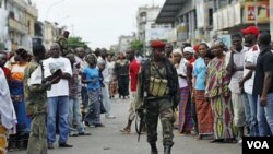 Warga di distrik Treichville, Abidjan menonton anggota pasukan Presiden Alassane Ouattara yang kini menguasai bekas markas pendukung Laurent Gbagbo.