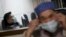 A patient (L) with fever receives treatment at the hospital where a 67-year-old H7N9 patient is being treated, in Hangzhou, Zhejiang province, April 3, 2013. 