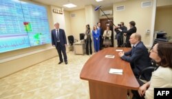 FILE - Russian President Vladimir Putin, second right, visits the center for the assessment of risks of money laundering and terrorist financing, Rosfinmonitoring, in Moscow, March 4, 2014.