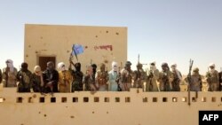 Des combattants d'un groupe armé local Gatia et du groupe armé pro-gouvernemental Mouvement de Salut de l'Azawad, se rassemblent devant leur siège dans la ville de Menaka le 21 novembre 2020.