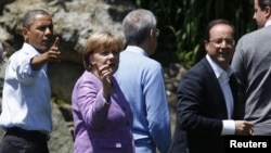 U.S. President Barack Obama, Germany's Chancellor Angela Merkel and French President Francois Hollande (L to R) face the media as the G8 leaders gather for a family photo at the G8 Summit at Camp David, Maryland, May 19, 2012