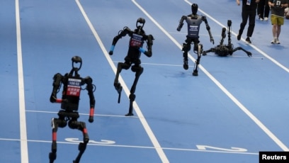 资料照片：在中国北京国家速滑馆举行的首届世界人形机器人运动会上，宇树科技和天工人形机器人参加了100米决赛。(2025年8月17日)