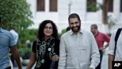 FILE - Alaa Abdel-Fattah, a leading pro-democracy activist, walks with his sister Mona Seif prior to a conference at the American University in Cairo, near Tahrir Square, Egypt, Sept. 22, 2014. 