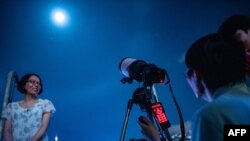 Les gens prennent des photos avant l'éclipse de Lune à Hong Kong le 28 juillet 2018.