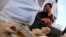 An Iraqi refugee woman from Mosul sits outside her family's tent at Khazir refugee camp outside Irbil, 217 miles (350 kilometers) north of Baghdad, Iraq, Friday, June 13, 2014.