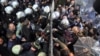 Riot police force a gate to enter the headquarters of opposition television stations and newspapers in Istanbul, Turkey, Oct. 28, 2015. 