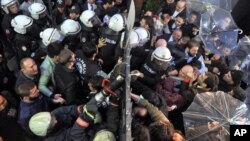 Riot police force a gate to enter the headquarters of opposition television stations and newspapers in Istanbul, Turkey, Oct. 28, 2015. 