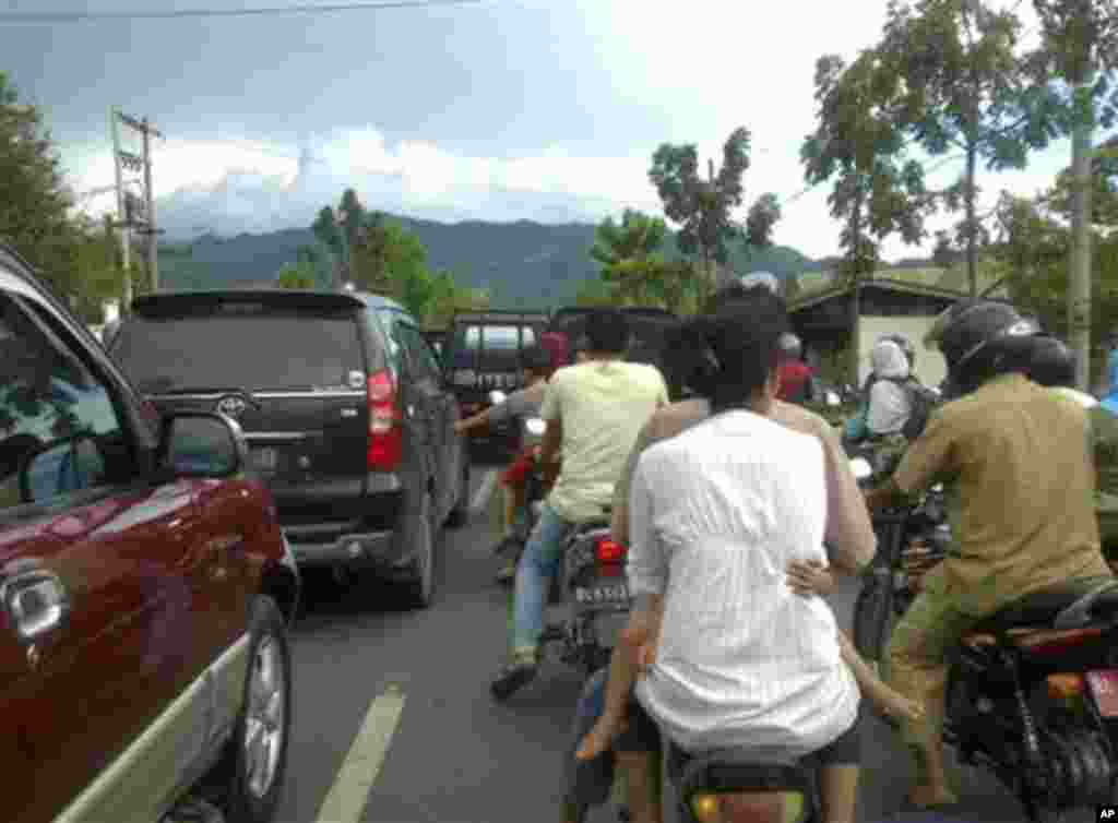 Warga memacu kendaraan mereka saat mengevakuasi diri setelah gempa terasa di Banda Aceh, Rabu, 11 April 2012 (AP Photo/Ichsan Ivansah). 