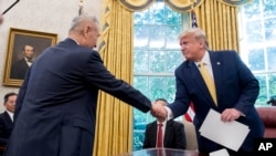 FILE - In this Oct. 11, 2019, photo, U.S. President Donald Trump shakes hands with Chinese Vice Premier Liu He after being given a letter in the Oval Office of the White House in Washington. 