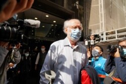El abogado estadounidense John Clancey sale de un edificio mientras los agentes de policía se lo llevan en Hong Kong, China, el 6 de enero de 2021.