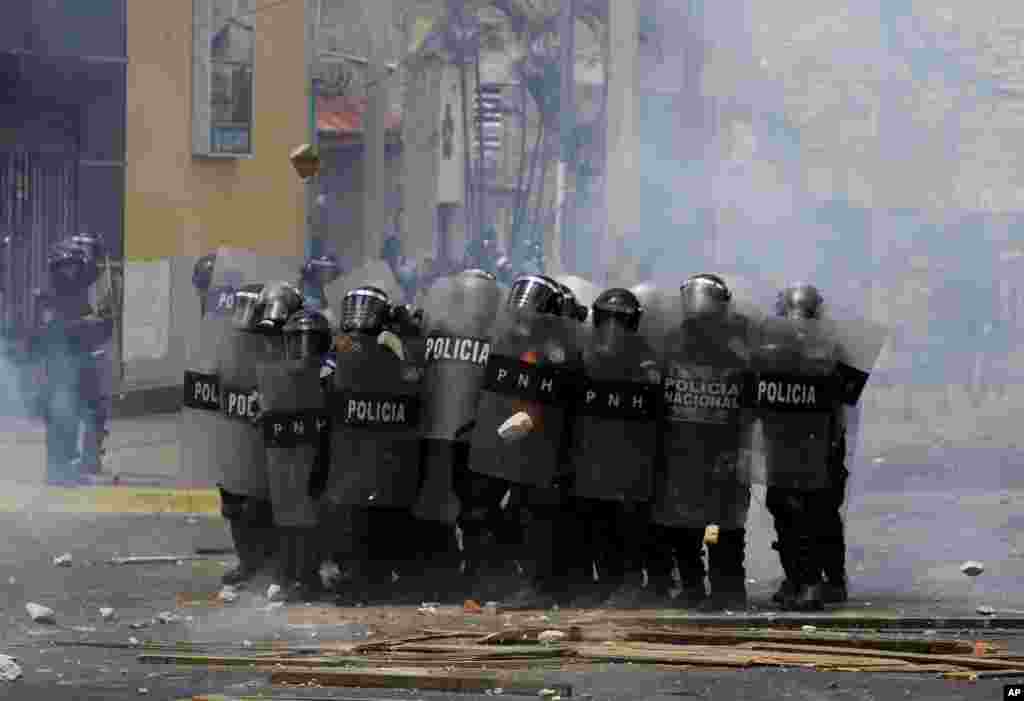 Police stand in riot gear as they face demonstrators during a protest demanding the resignation of President Juan Orlando Hernandez, in Tegucigalpa, Honduras, September 15, 2019.