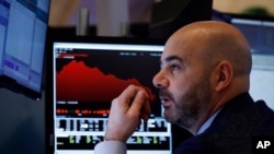 Trader Fred DeMarco works on the floor of the New York Stock Exchange, Feb. 28, 2020. Global stock markets are falling further on spreading virus fears.