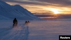 FILE: Para ilmuwan mengendarai mobil salju mereka melintasi Arktik menuju Kongsfjord saat matahari terbenam di dekat Ny-Alesund, Svalbard, Norwegia, 10 April 2023. (Lisi Niesner/REUTERS)