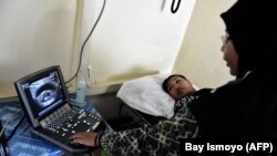 Seorang dokter melakukan USG pada seorang ibu hamil di sebuah klinik kesehatan nirlaba di Sukadana, Kalimantan Barat. (Foto: AFP/Bay Ismoyo)