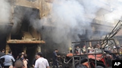 In this photo released by the Syrian official news agency SANA, Syrian citizens gather in front of a damaged building that was destroyed by a car bomb, at Jaramana neighborhood, in Damascus, Syria, Monday Oct. 29, 2012.