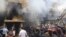 In this photo released by the Syrian official news agency SANA, Syrian citizens gather in front of a damaged building that was destroyed by a car bomb, at Jaramana neighborhood, in Damascus, Syria, Monday Oct. 29, 2012.