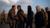 A man is frisked by a U.S.-backed Syrian Democratic Forces fighter after being evacuated out of the last territory held by Islamic State militants, near Baghuz, eastern Syria, Feb. 22, 2019.