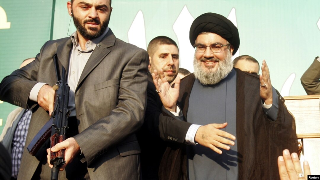 Lebanon's Hezbollah leader Sayyed Hassan Nasrallah (R), escorted by his bodyguards, makes a rare public appearance as he greets his supporters at an anti-U.S. protest in Beirut's southern suburbs September 17, 2012. 