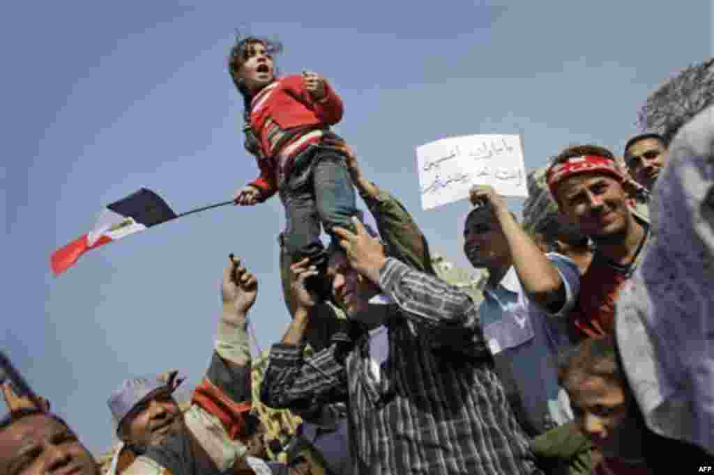 A young girl standing on a relative's shoulders leads chants against Egyptian President Hosni Mubarak during the continuing demonstration in Tahrir square in downtown Cairo, Egypt, Tuesday, Feb. 1, 2011. More than a quarter-million people flooded into the