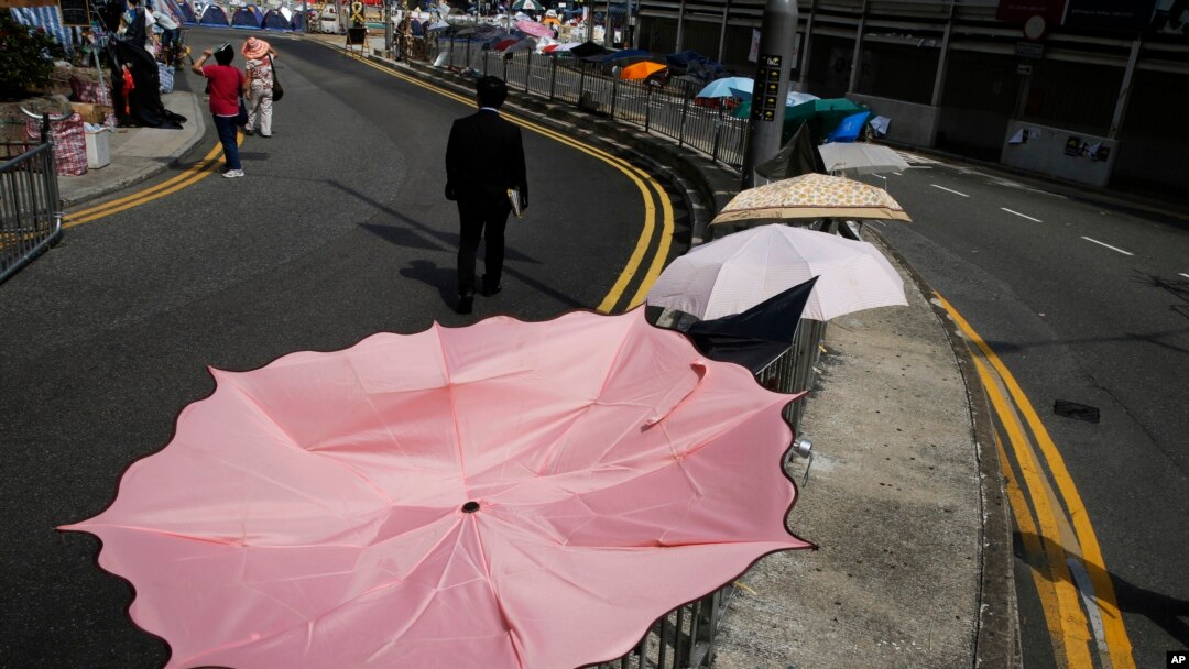 A man walks past an umbrella installation in the occupied area outside government headquarters in Hong Kong's Admiralty, Oct. 28, 2014.