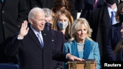 Joe Biden is sworn in as the 46th President of the United States as his wife Jill Biden holds a Bible on the West Front of the U.S. Capitol in Washington, Jan. 20, 2021.