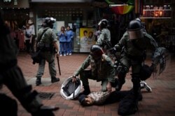 An anti government protester is detained by police at Tseun Wan, Hong Kong, Oct.13, 2019.