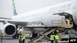 FILE - Workers unload a shipment of the Johnson & Johnson COVID-19 vaccine from an airplane at O. R. Tambo International Airport in Johannesburg, South Africa, Feb. 27, 2021.