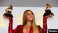 FILE - Beyonce holds the awards she won at the 59th Annual Grammy Awards in Los Angeles, California, Feb. 12, 2017. 