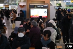 Orang-orang menonton layar televisi yang menayangkan siaran berita tentang uji coba rudal Korea Utara, di stasiun kereta api di Seoul pada 14 Januari 2024. (Foto: AFP)