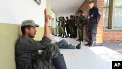 Un rebelde de las FARC capturado por la policía hace la señal de la victoria. Seis policías fueron asesinados por guerrilleros en el sureste de Colombia.